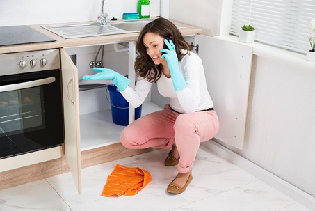 A woman calling a plumber for an emergency