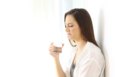 Woman frowning at odor in her water